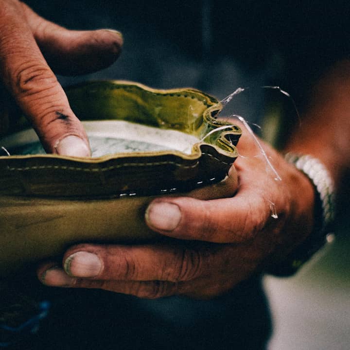 A bootmaker checking his work by tapping a midsole