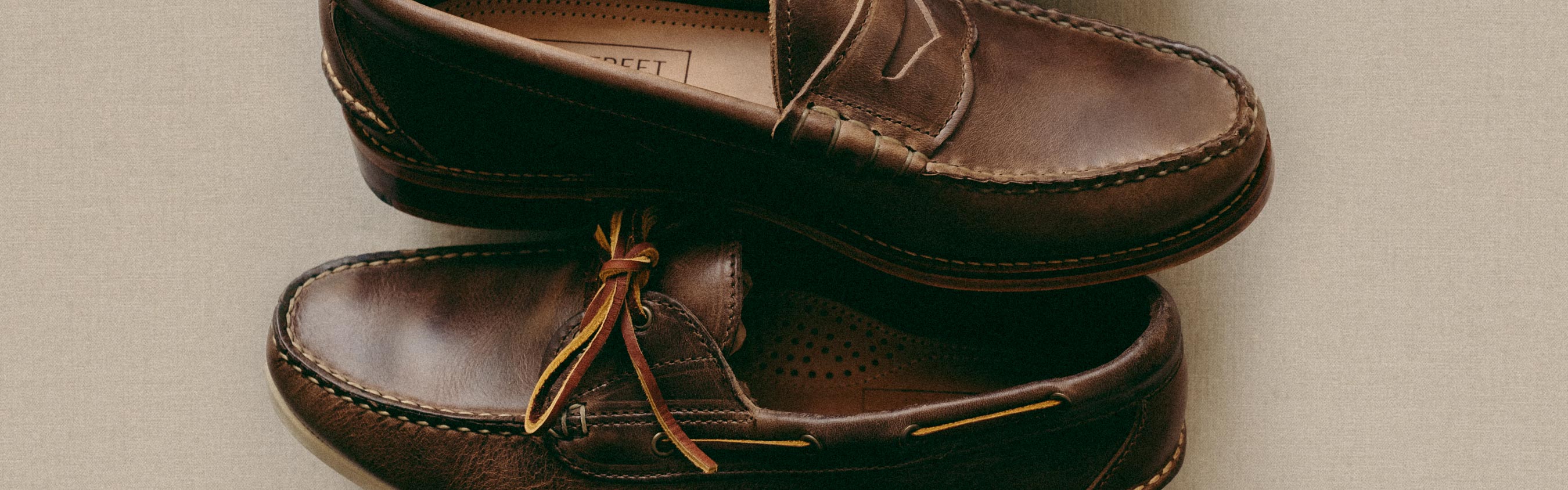 A close-up of a hand-sewn Boat Shoe and hand-sewn Penny Loafer